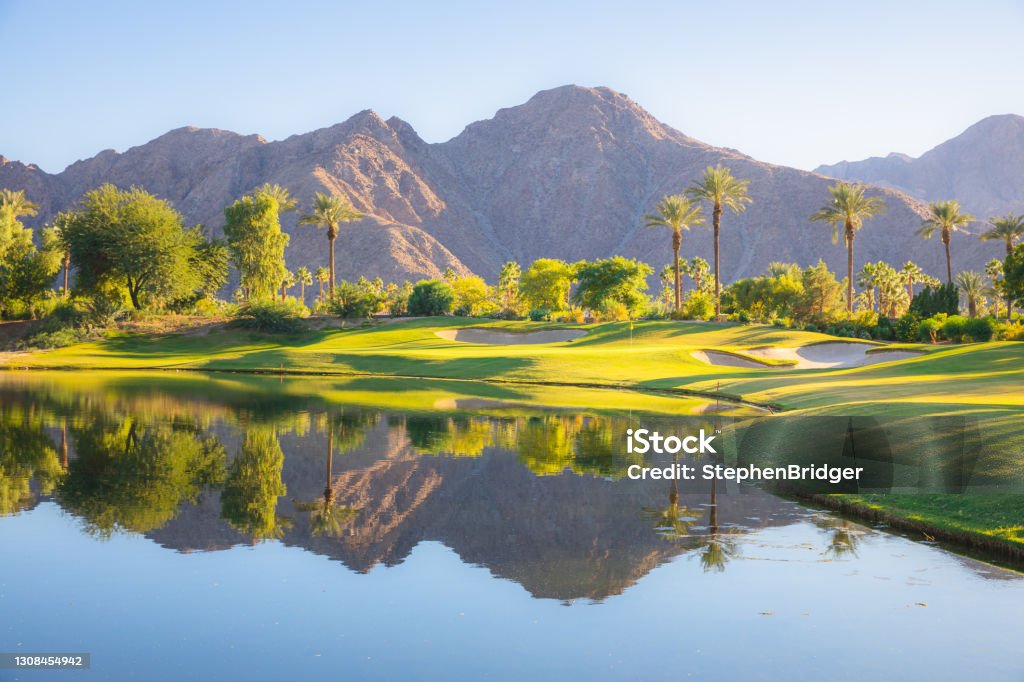 Indian Wells Golf Course, California Beautiful golden light over Indian Wells Golf Resort, a desert golf course in Palm Springs, California, USA with view of the San Bernardino Mountains. Palm Springs - California Stock Photo