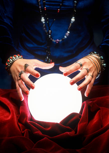 fortune teller hands on glowing crystal ball close up on female gypsy hands on a glowing crystal ball crystal ball stock pictures, royalty-free photos & images