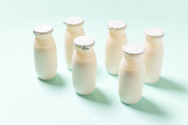 istock Small bottles with probiotics and prebiotics dairy drink on blue background. Production with biologically active additives. Fermentation and diet healthy food. Bio yogurt with useful microorganisms 1308455290