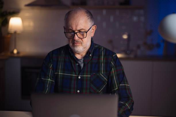 istock Mature freelancer using laptop from home at night 1308455365