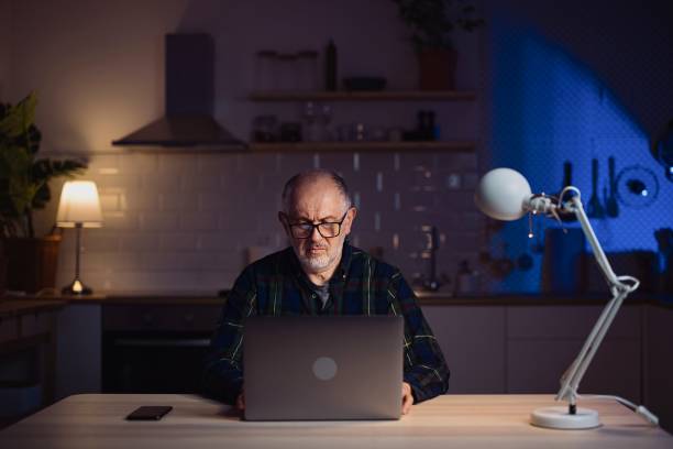 istock Confident middle aged man with laptop in home office 1308455366