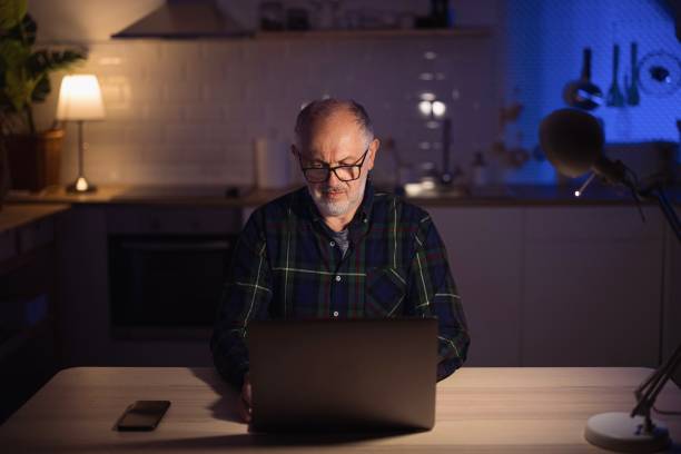 istock Confident middle aged man with laptop in home office 1308455391