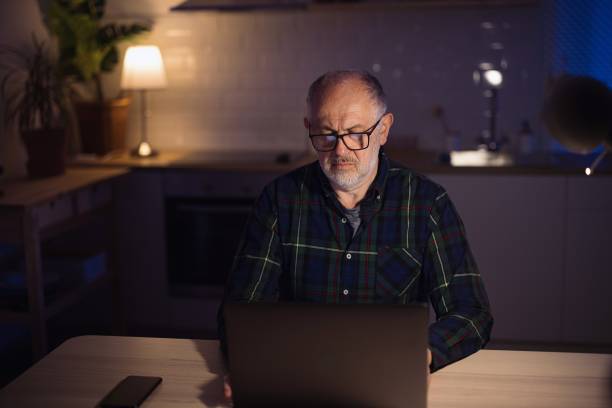 istock Mature freelancer using laptop from home at night 1308455411