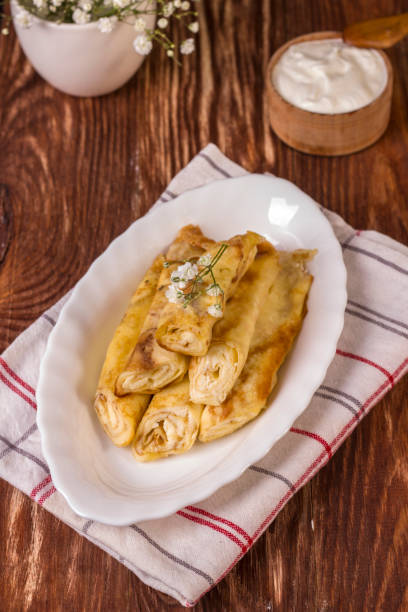 istock Rolled up thin pancakes stuffed with cottage cheese with raisins 1308458227