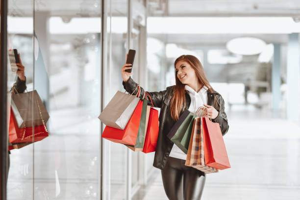 istock Beautiful Female Taking Selfie While Shopping In Big Mall 1308459163