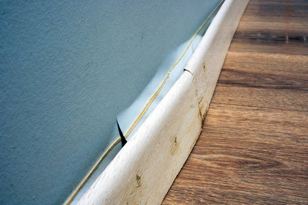 battiscopa danneggiato staccato dal muro dopo che l'appartamento è stato allagato. - chores wood wet indoors foto e immagini stock