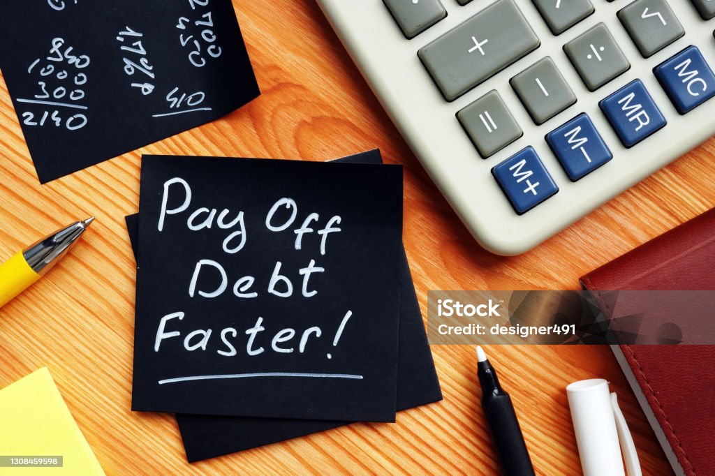 Pay off debt faster handwritten memo and calculator. Pay off debt faster handwritten memo and pen. Debt Stock Photo