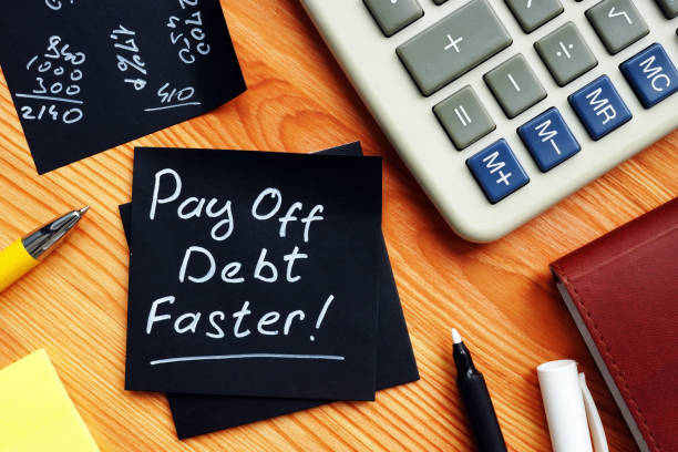 pay off debt faster handwritten memo and calculator. - bribing imagens e fotografias de stock