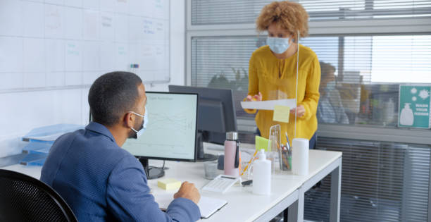 istock Business people talking through glass partition in office 1308460506