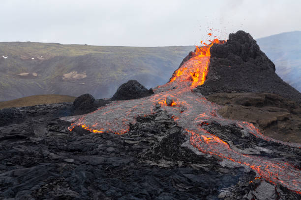 Volcanic eruption in Iceland Geldingadalir, Iceland - March 21, 2021: A small volcanic eruption started at the Reykjanes peninsula. The event has attracted thousands of visitors who have braved a daring hike to the crater. igneous rock stock pictures, royalty-free photos & images