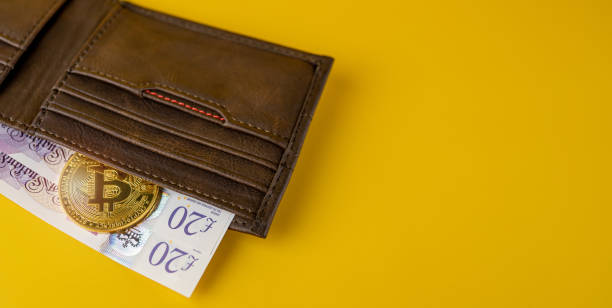bitcoin with british pounds cash in a wallet on yellow background - ações de bolsa imagens e fotografias de stock