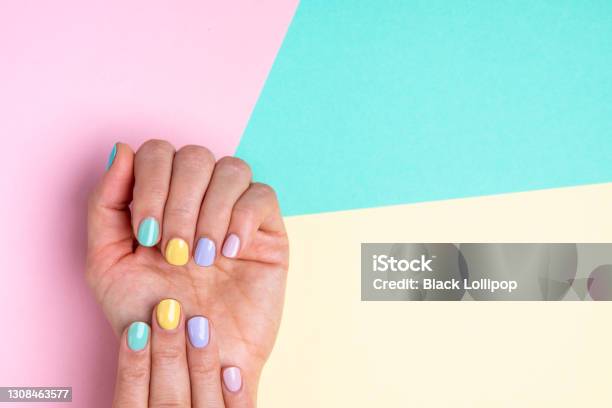 Hands With Pastel Nail Polish On Multicolored Background Stock Photo - Download Image Now