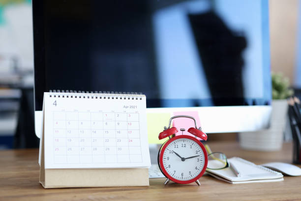 istock Calendar for April 2021 is on desktop next to alarm clock 1308463957