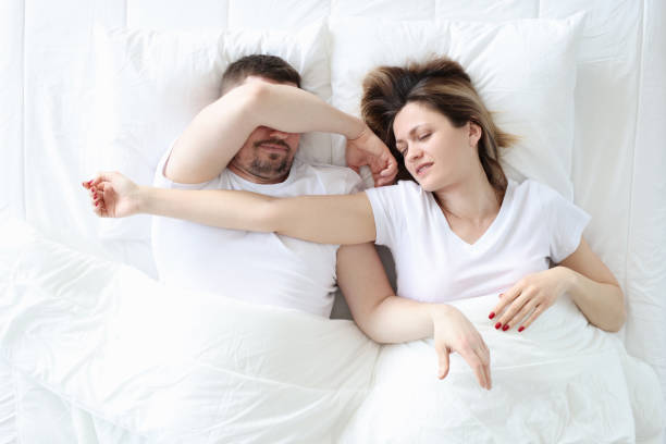 istock Young man and woman are sleeping on large white bed 1308463966