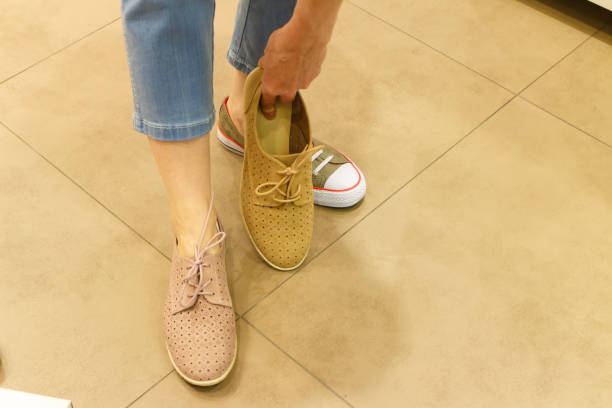 istock Unrecognizable woman trying on shoes 1308464034