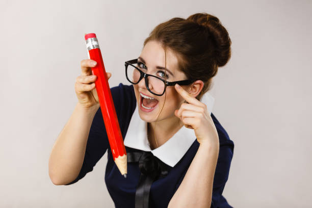 istock Smiling woman holds big pencil in hand 1308465434