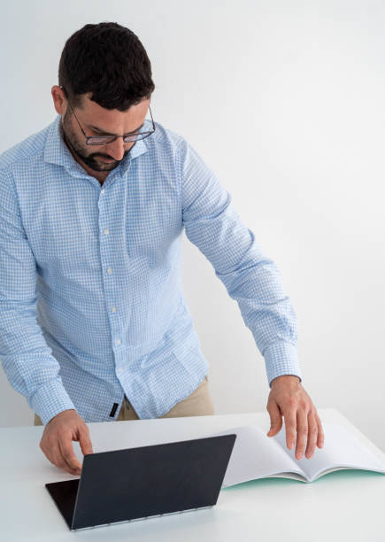 istock Employee telecommuting from home wearing a blue and white plaid shirt and a computer 1308469168