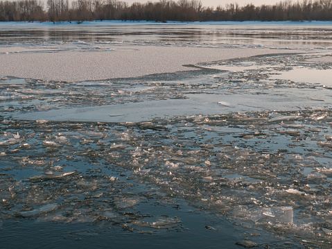 Spring ice drift on the Siberian river at sunset, pieces of ice in the water, Western Siberia, the Ob River, Siberian landscapes