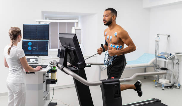 Interpretation Of The Electrocardiogram Of Young Athletes Athlete does a cardiac stress test in a medical study, monitored by the female doctor. stress test stock pictures, royalty-free photos & images