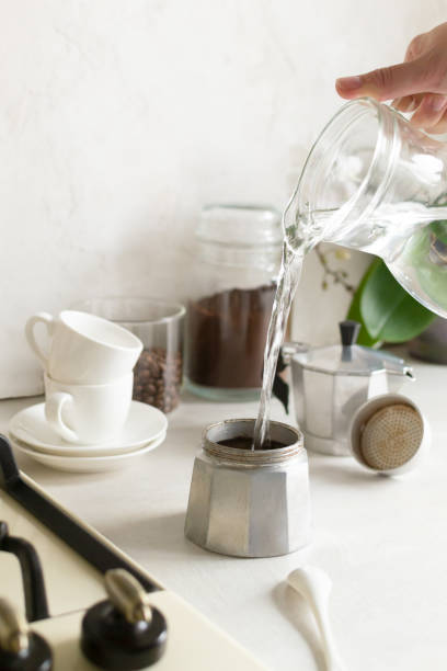 istock Water is poured from a jug into a geyser coffee maker. 1308475123