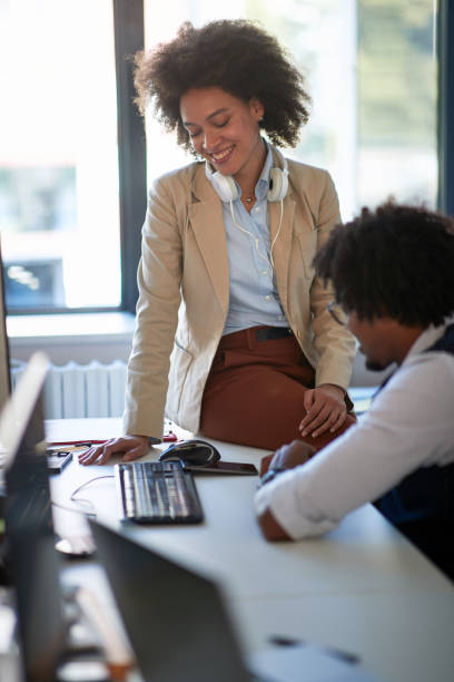 istock two colleagues smiling and watching info on cell phone. Casual business concept 1308476042