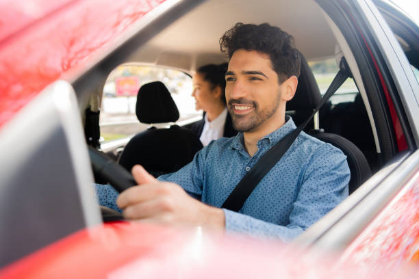 istock Taxi driver with passenger at back seat. 1308476058