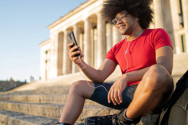 istock Latin man using mobile phone outdoors. 1308476104
