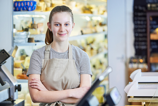 Retrato de adolescente trabajando en delicatessen food shop como experiencia laboral photo