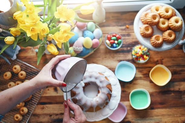 Preparing Small Easter Bunt Cakes with Icing Preparing Small Easter Bunt Cakes with Icing easter cake stock pictures, royalty-free photos & images