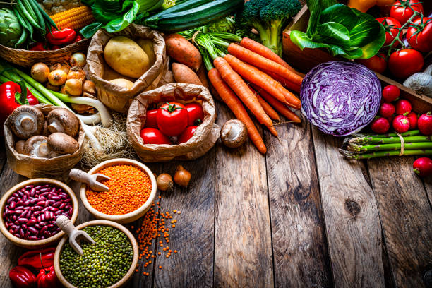 istock Healthy food: fresh organic vegetables and legumes on rustic wooden table. Copy space 1308478984