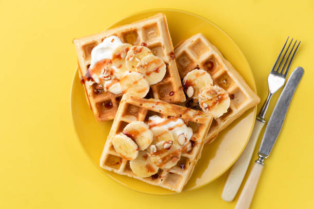 gofres belgas con plátano, salsa de caramelo y almendras - waffle belgian waffle belgian culture isolated fotografías e imágenes de stock