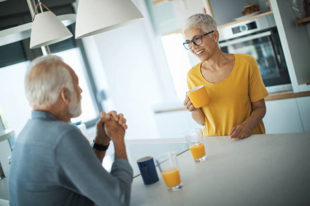istock Mature couple having a morning coffee at a kitchen counter. 1308479999