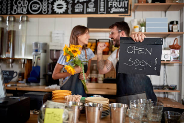 istock Coffee bar is open -  owner with open sign in their cafe store. 1308482853