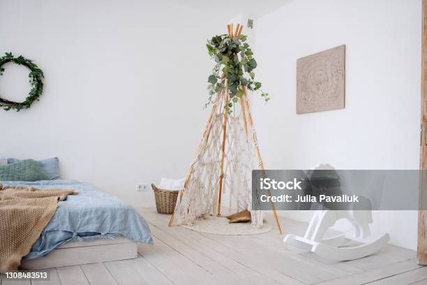 Stylish Trendy Interior In Scandinavian Style In White Loft Room There Is Wigwan Macrame With Green Ivy Bed On The Floor Wooden Rocking Horse Handmade Hammock Hanging By The Window Copy Space Stock Photo - Download Image Now