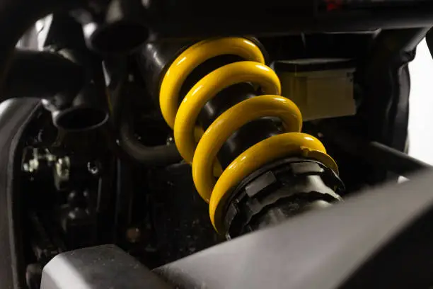 Close Up of Motorcycle Superbike Yellow Shock Absorber and Spring of the back wheel