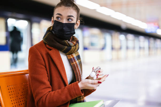 istock Student girl with mask disinfecting hands 1308486388