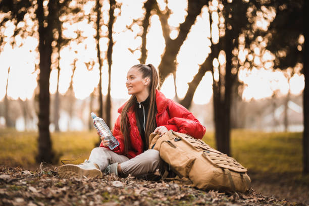 istock Success woman hiker taking a break and drinking water at sunrise 1308486637