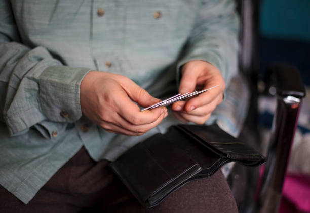 Businessman in black suit picking credit card in wallet on blur background of shop at mall.