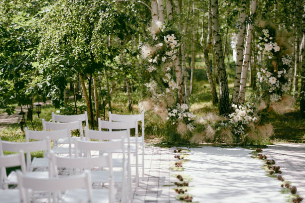 lugar para la ceremonia de boda en el jardín, espacio de copia. arco de boda decorado con flores y sillas blancas a cada lado del arco al aire libre. ajuste de la boda - wedding venue fotografías e imágenes de stock