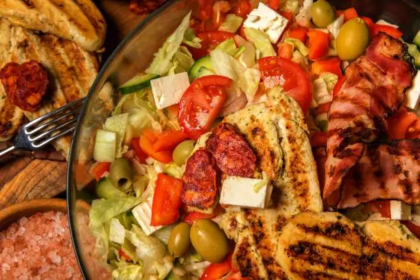 Vegetable salad with chicken and bacon. Salad with tomatoes and cheese. Diet food. Chicken steak with vegetables.