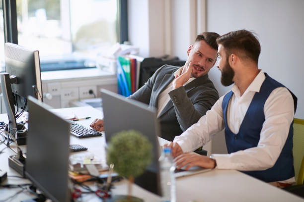 istock Young business colleagues in office.Mens talking at work in modern office. 1308492745