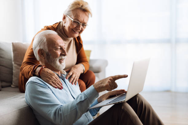 istock Happy mature couple relaxing  at home and using laptop 1308494987