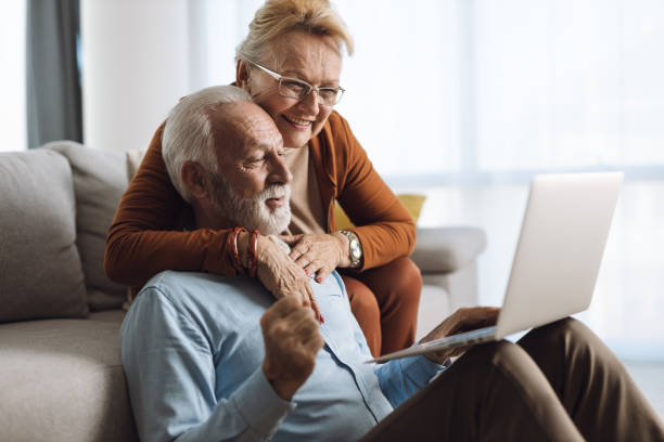 istock Happy mature couple relaxing  at home and using laptop 1308495068