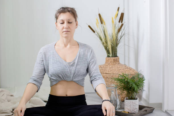 istock Woman relaxing indoors meditating and doing breathing exercises 1308498025
