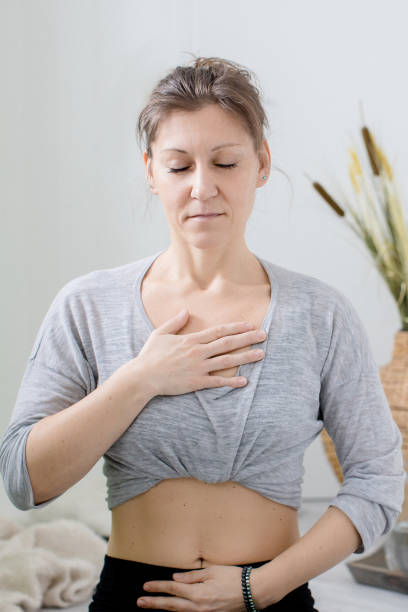istock Woman relaxing indoors meditating and doing breathing exercises 1308498093