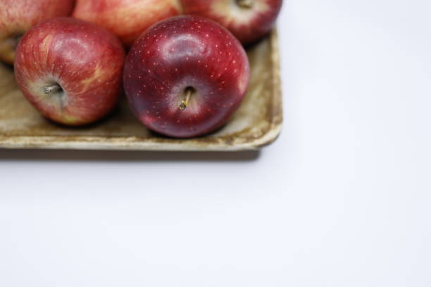 Istanbul, Turkey-March 21, 2021: Red apples on a wooden plate on a white background, Full Frame, Studio shot, Still life, Flat lay, Flash. Shot with Canon EOS R5.