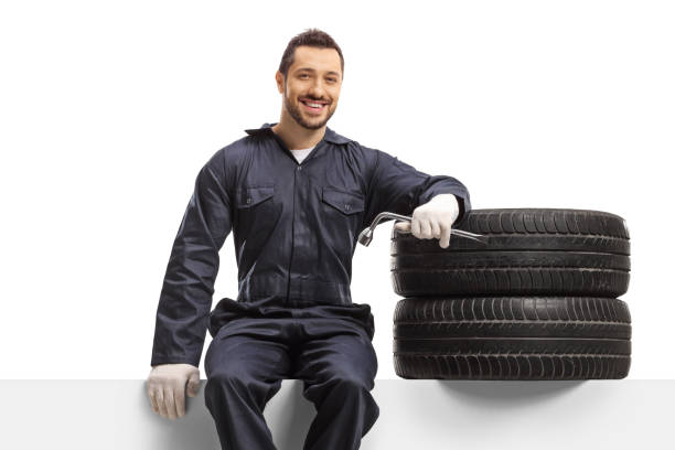 istock Mechanic sitting on a panel with tires 1308505468