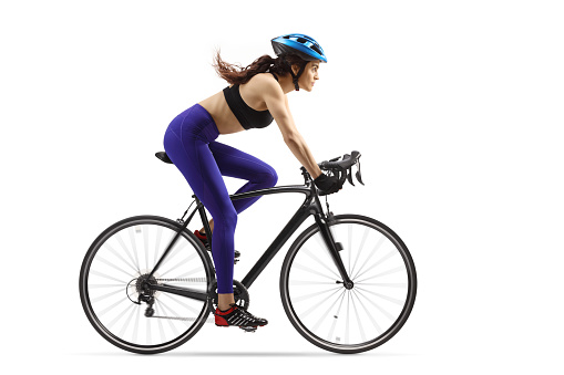 Female athlete riding a bicycle with a helmet isolated on white background
