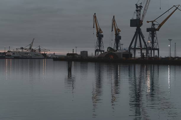 Belfast, Northern Ireland, United Kingdom - March 21, 2020: Reflections of cranes at Belfast's shipyard (Harland and Wolff) and a Stena line ferry that connects Northern Ireland with Scotland.
