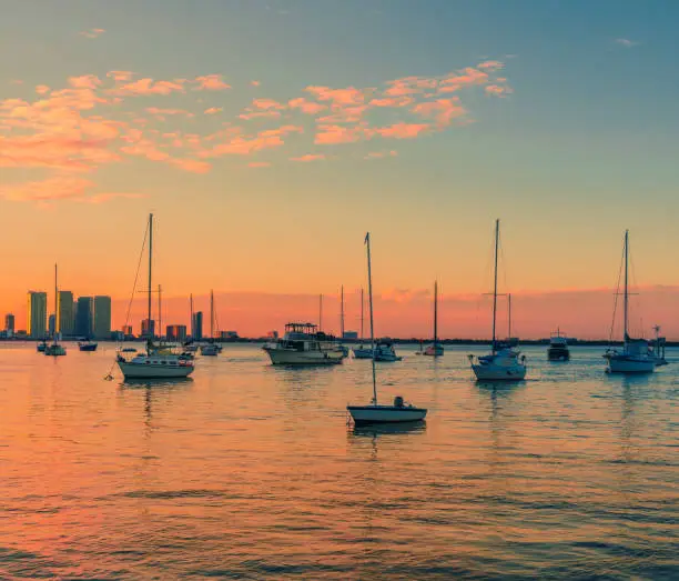 Photo of beautiful sunset scene sky boats sea horizon buildings clouds